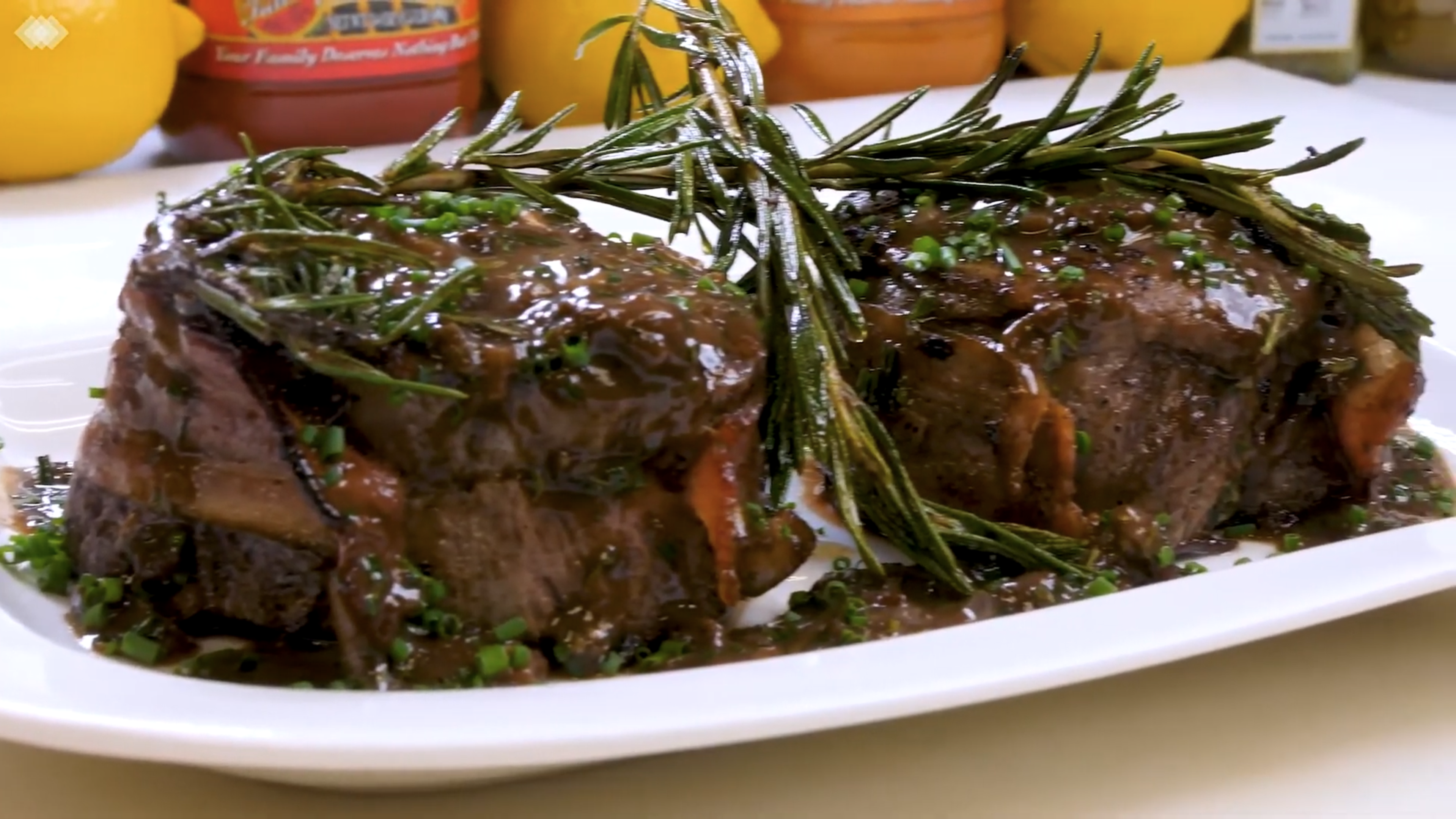 Bacon wrapped filet mignons on a plate with sauce
