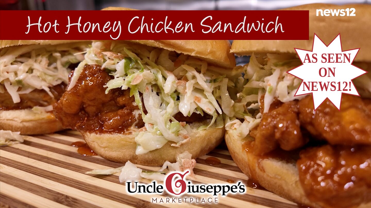 Three hot honey chicken sandwiches on a striped cutting board