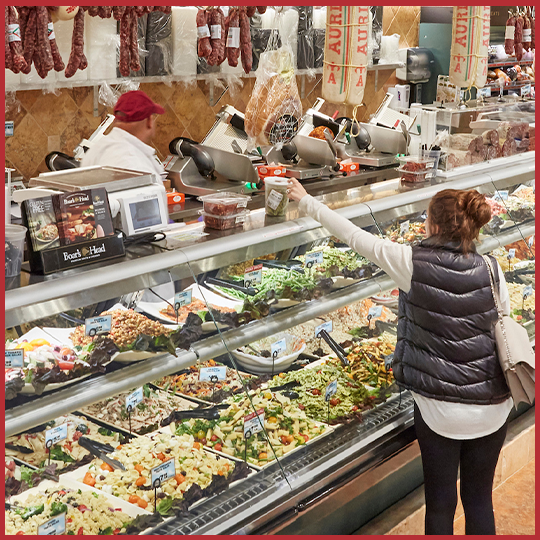 Deli customer reaching to grab their order in Uncle Giuseppe's